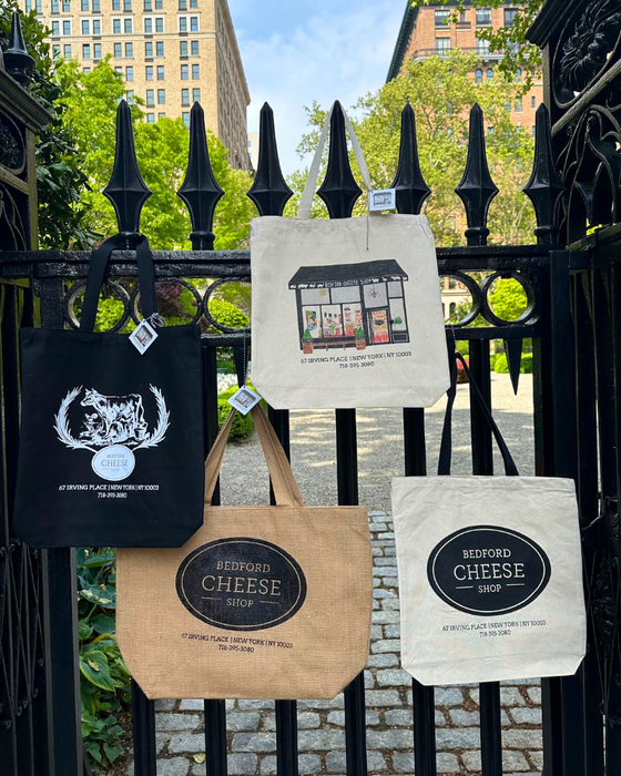 Image is of the BCS tote bags (4 designs) hanging from a black iron gate.